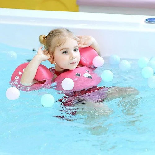 petite fille avec brassards petit moussaillon qui nage dans une piscine sur le dos