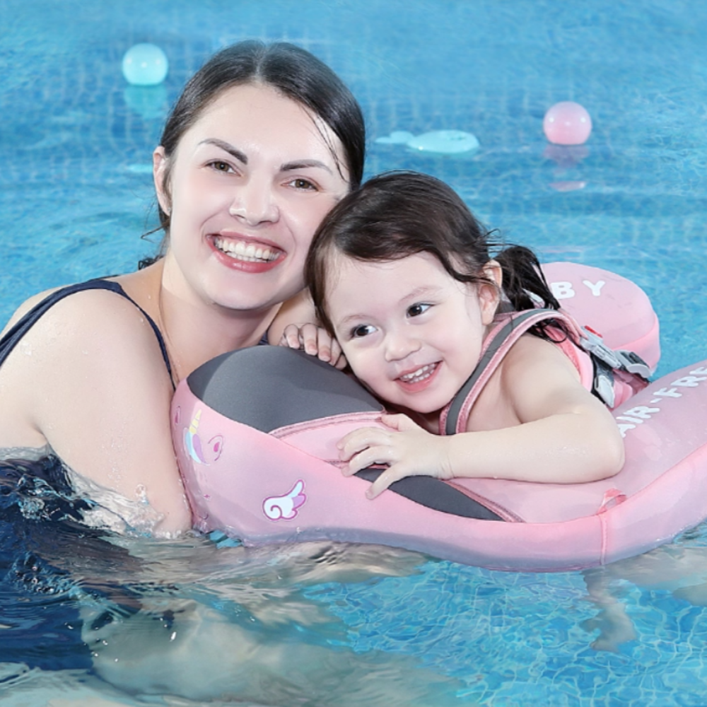 maman et sa fille de 2 ans dans un flotteur petit moussaillon rose à la piscine