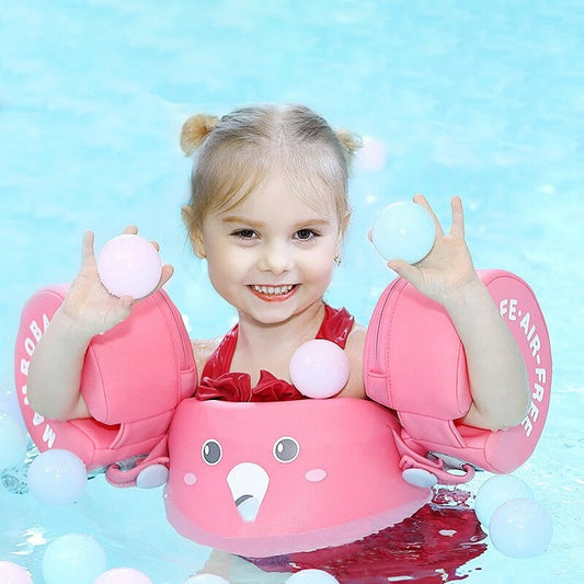 petite fille de 4 ans avec les brassards petit moussaillon rose dans une piscine
